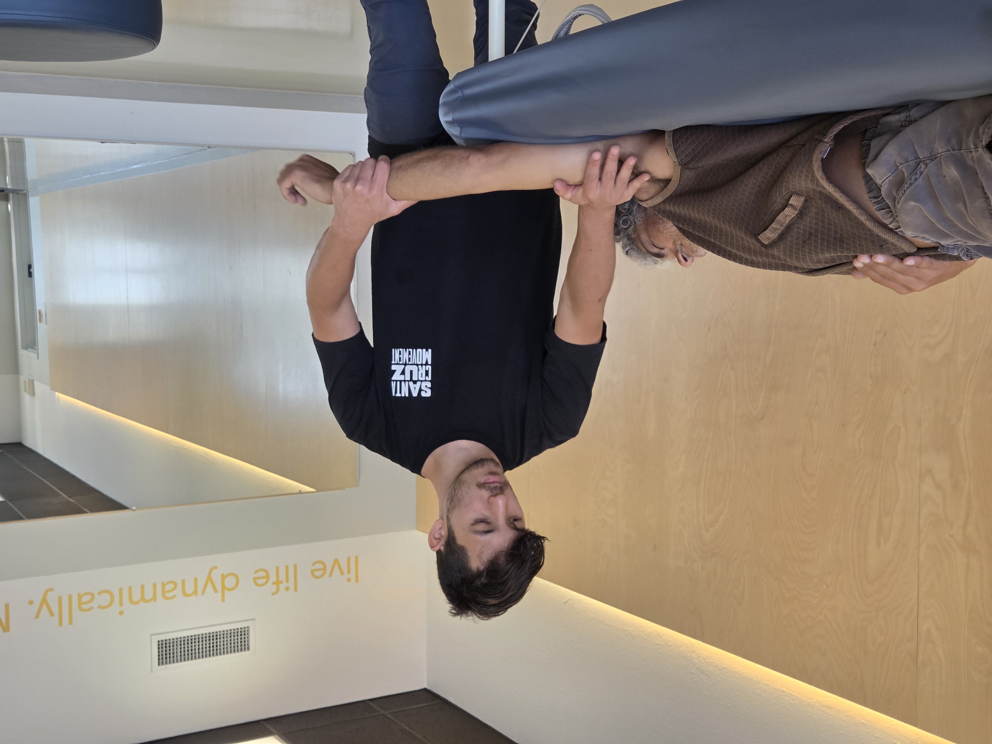 Cole supporting a client's arm during a Form & Flow session